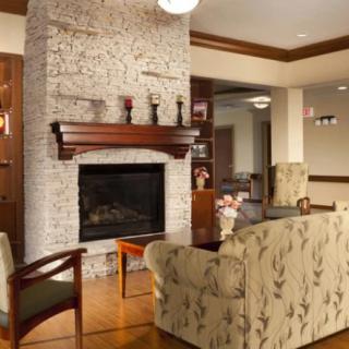 A cozy living room with a stone fireplace and elegant furnishings.