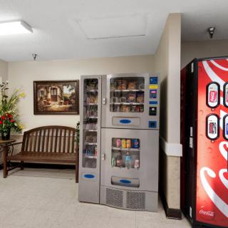 A cozy waiting area featuring vending machines, a wooden bench, and decorative elements.