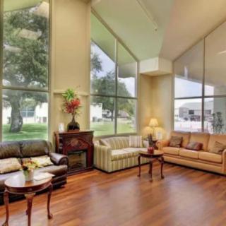 A spacious living room with large windows, comfortable sofas, and elegant wooden flooring.