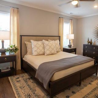 A cozy bedroom with a wooden bed frame, neutral bedding, and stylish decor.