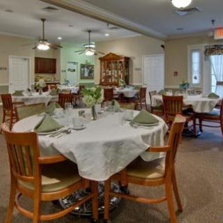 A well-set dining room with neatly arranged tables and chairs.