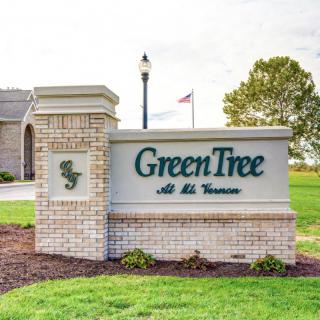 A sign for GreenTree at St. Andrews placed in front of a building with landscaping.
