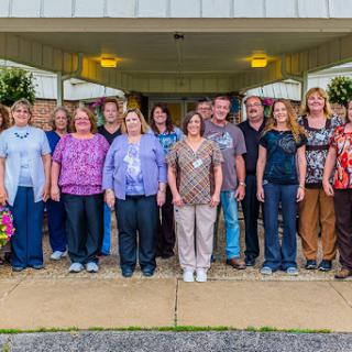 Staff members gather for a group photo outside the building.
