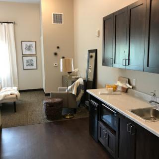 A cozy living space featuring a kitchenette, comfortable seating, and minimalist decor.