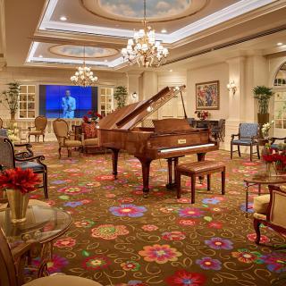 A luxurious room featuring a grand piano, elegant furniture, and vibrant decor.