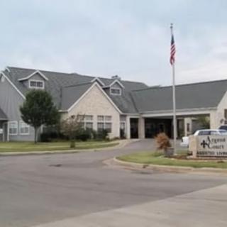 A view of a building with a driveway and an American flag on a flagpole.