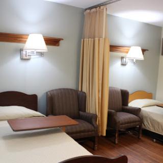 A cozy hotel room featuring two beds, comfortable seating, and warm lighting.