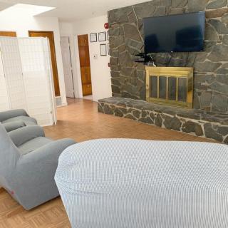A cozy living room with a stone fireplace and mounted television.