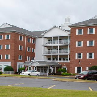 A brick residential building featuring multiple balconies and a welcoming entrance.