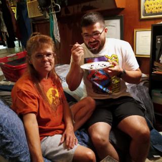 Two friends enjoying a moment together, one eating from a plate.
