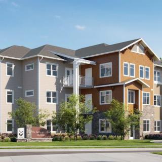 A modern suburban apartment building with a mix of neutral and earthy tones.