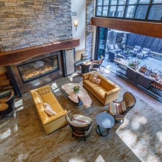 A stylish living room featuring a modern fireplace, ample seating, and large windows allowing natural light.
