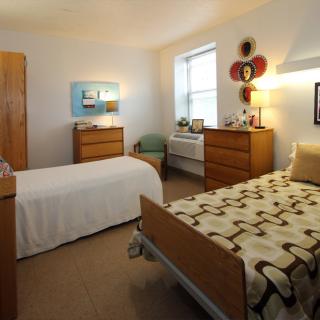 A cozy bedroom with two twin beds and wooden furniture.