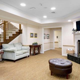 A cozy living room featuring a staircase, comfortable seating, and a fireplace with a TV above.