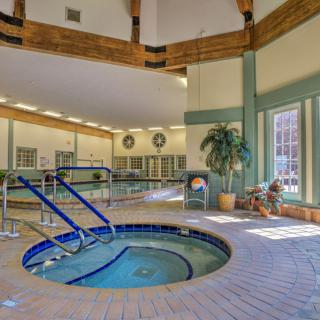 An inviting indoor spa with a hot tub, seating area, and natural lighting.
