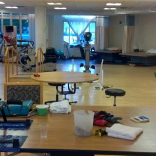 A spacious physical therapy room equipped with rehabilitation tools and exercise equipment.