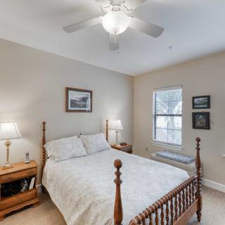 A cozy bedroom with a wooden bed, matching bedside table, and wall decor.
