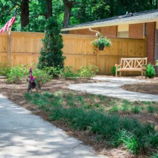 A well-maintained yard with a paved pathway and garden bench.