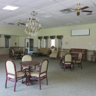 A spacious room featuring elegant furniture and a chandelier.