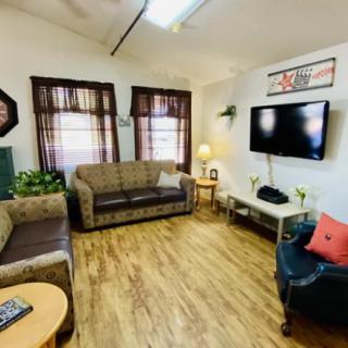 Cozy living room with sofas, a TV, and wooden flooring.