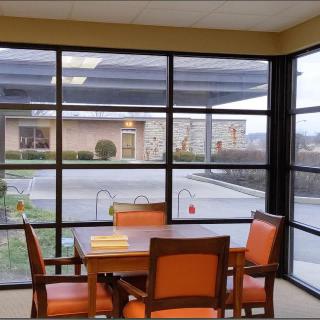 A modern indoor seating area with a table and chairs by large windows.