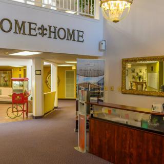 A welcoming lobby area with homey decor, featuring a reception desk and a popcorn machine.