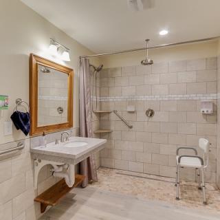 A spacious, accessible bathroom with grab bars and a walk-in shower.