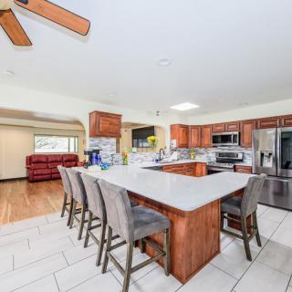 A spacious modern kitchen featuring a large island with bar stools and stainless steel appliances.