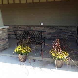 A cozy patio setting with a bench and potted plants.