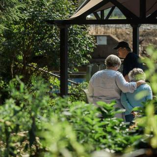 A serene moment with people enjoying the outdoors under a gazebo.
