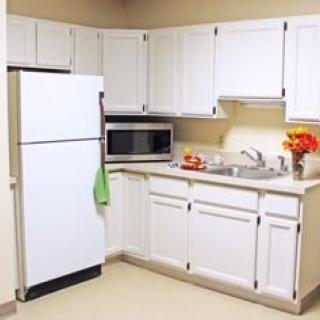 A modern kitchen with white cabinets and appliances.