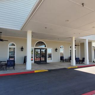 Entrance of a building with columns and a covered patio area.