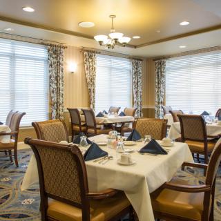 An elegant dining room with neatly set tables and comfortable chairs.