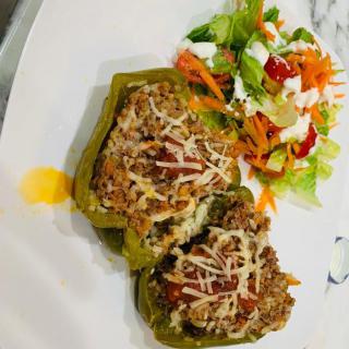 A plate of stuffed peppers accompanied by a fresh salad.
