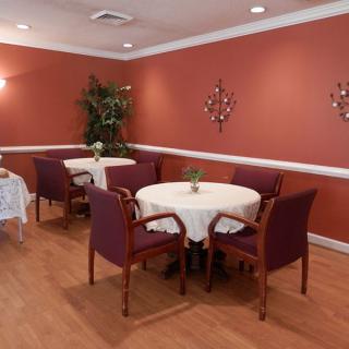 An elegant dining area with round tables and chairs, featuring warm tones and tasteful decor.