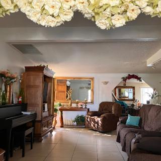 A cozy and inviting living room featuring comfortable brown sofas, a piano, and decorative elements.