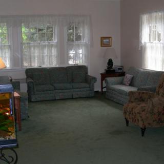 A cozy living room with couches, a chair, and a fish tank.