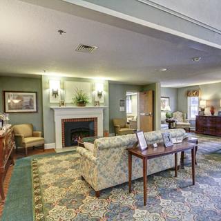 A cozy living room featuring a comfortable sofa, elegant carpet, and a warm fireplace.
