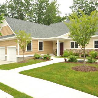 A well-maintained suburban house with a landscaped front yard and driveway.