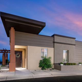 A modern house exterior at dusk with a beautifully colored sky.