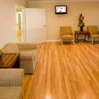 A spacious waiting room with comfortable seating and a wooden floor.