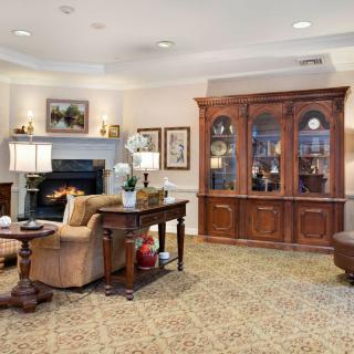 A cozy living room featuring a fireplace, wooden furniture, and elegant decor.