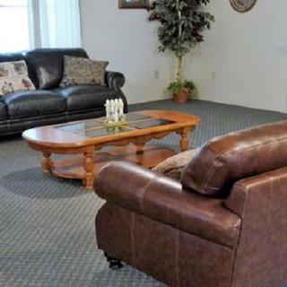 A cozy living room featuring leather sofas and a wooden coffee table.