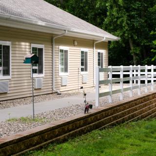 A house with a well-maintained yard and white fencing.
