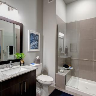 A modern bathroom featuring a glass-enclosed shower, vanity with sink, and contemporary decor.