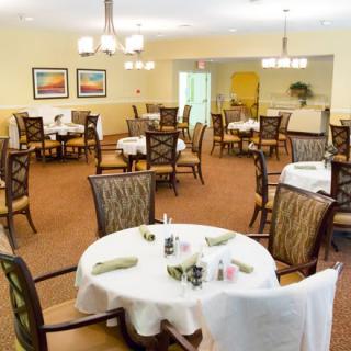 A well-lit dining area with neatly arranged tables and chairs.