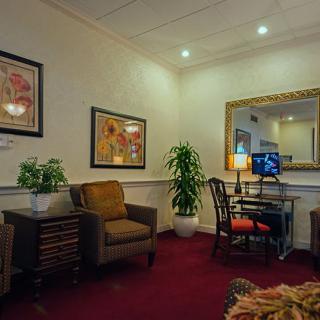 A cozy living room with comfortable seating, decorative plants, and framed artwork on the walls.