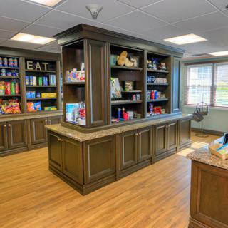 A cozy library interior with wooden bookshelves filled with books and decorative items.