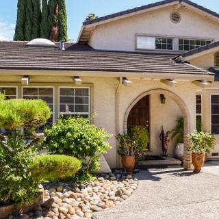A charming residential house with a well-maintained garden and pathway.