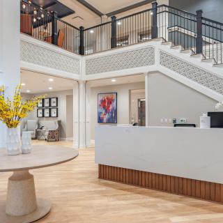 A modern reception area featuring a staircase, contemporary artwork, and elegant decor.